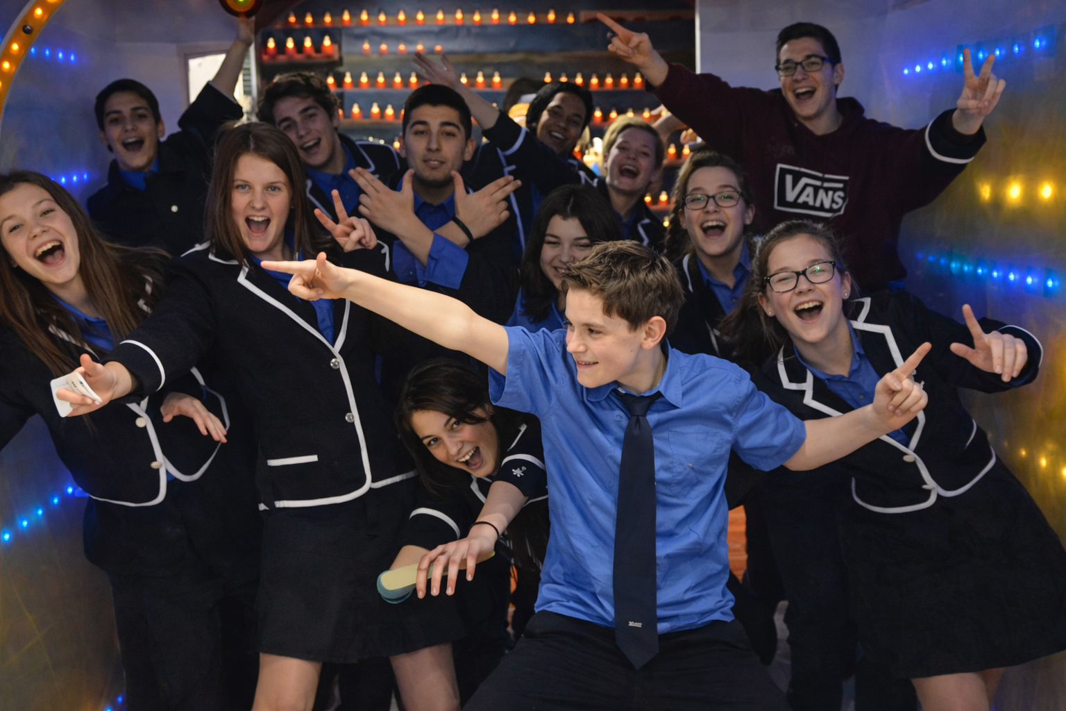 Groupe de jeunes célébrant ensemble dans une ambiance joyeuse et dynamique.